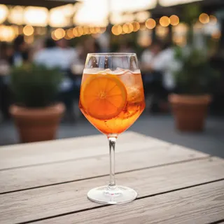Weißer Spritzer mit Eis und Orange