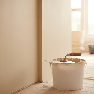 Frisch verputzte Wand, Kelle auf dem Kübel